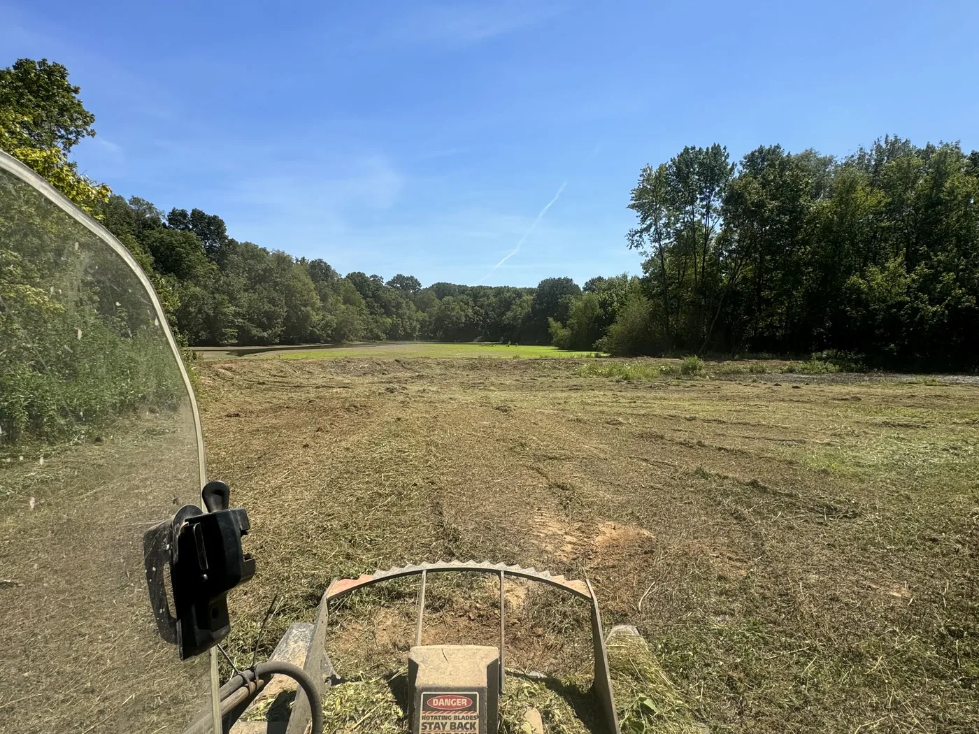 Freshly bush hogged strip across an open field, seen from the cab
