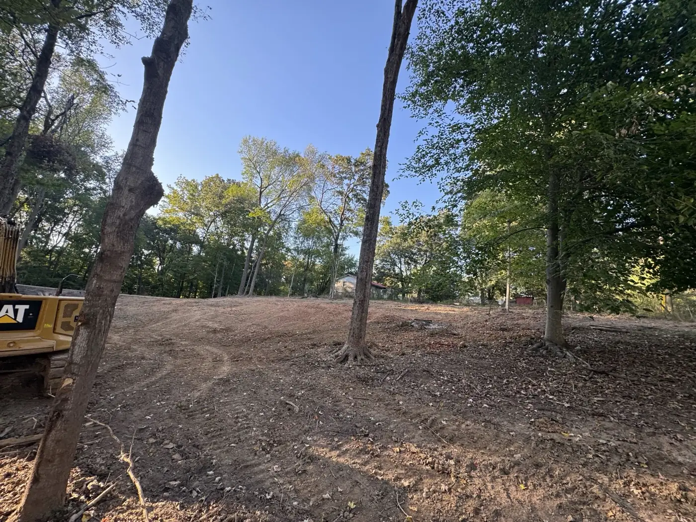 Excavator on a cleared lot during site prep